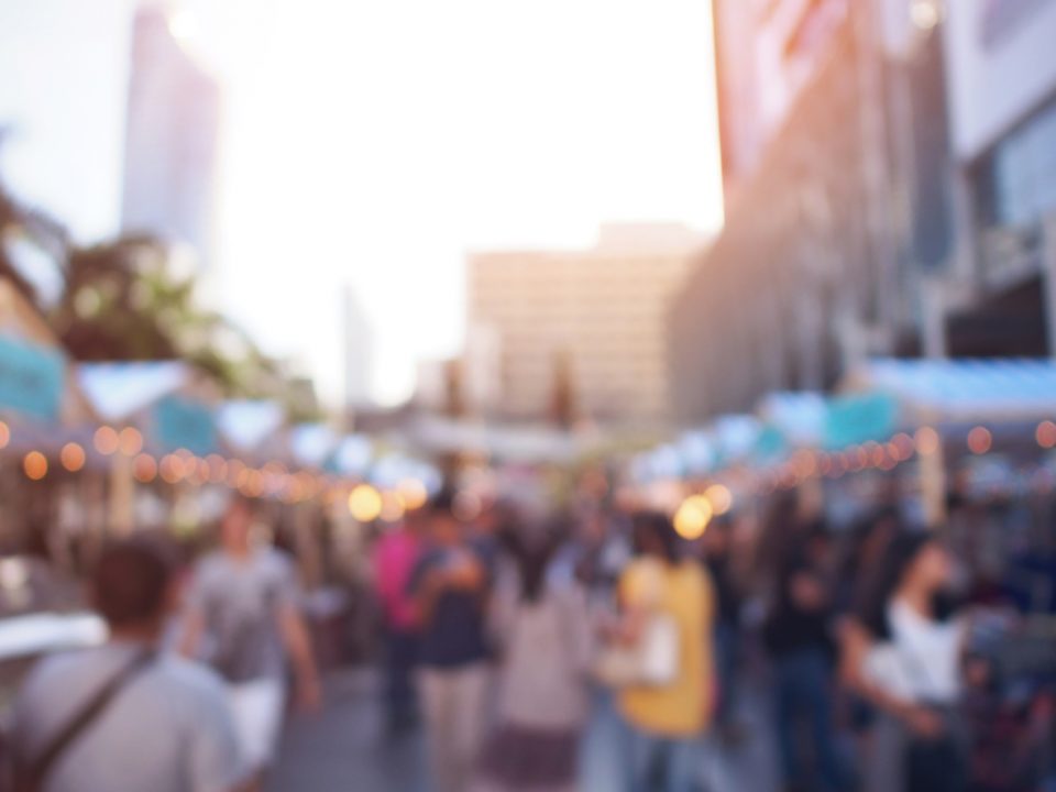 People walking and shopping at market fair in the evening.