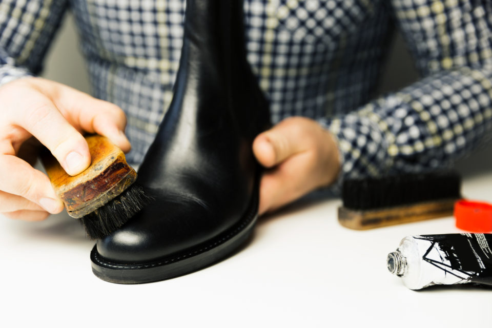 Cobbler's hands cleaning shoes with a brush