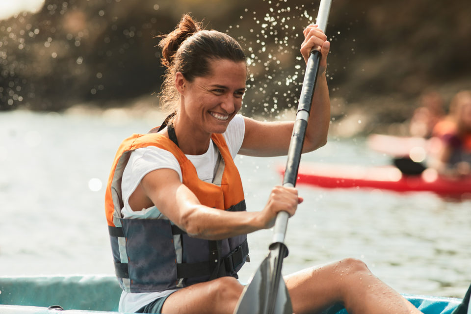 Woman kayaking with life jacket on