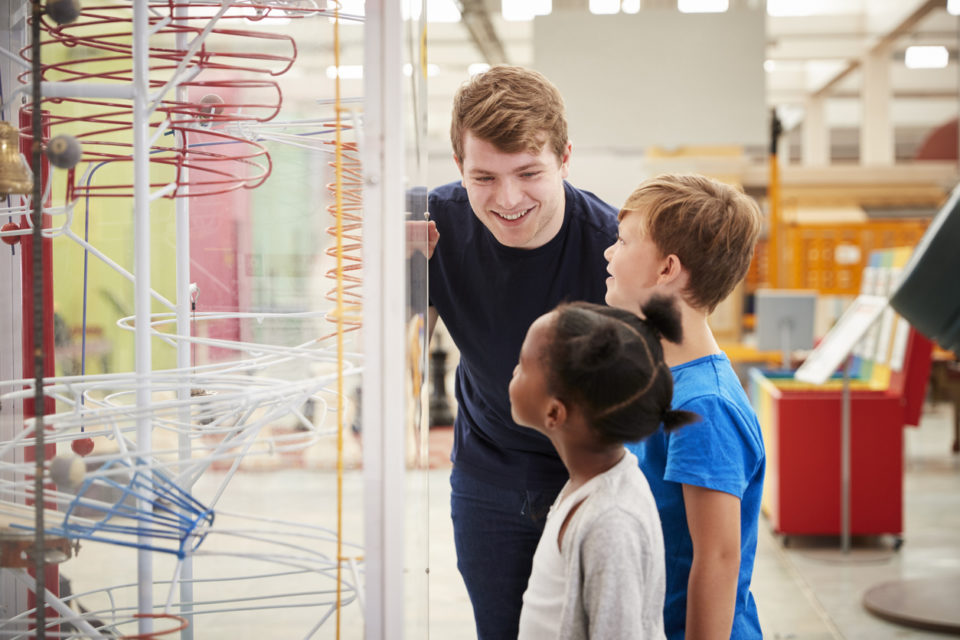 Teacher and kids talking about a science exhibit