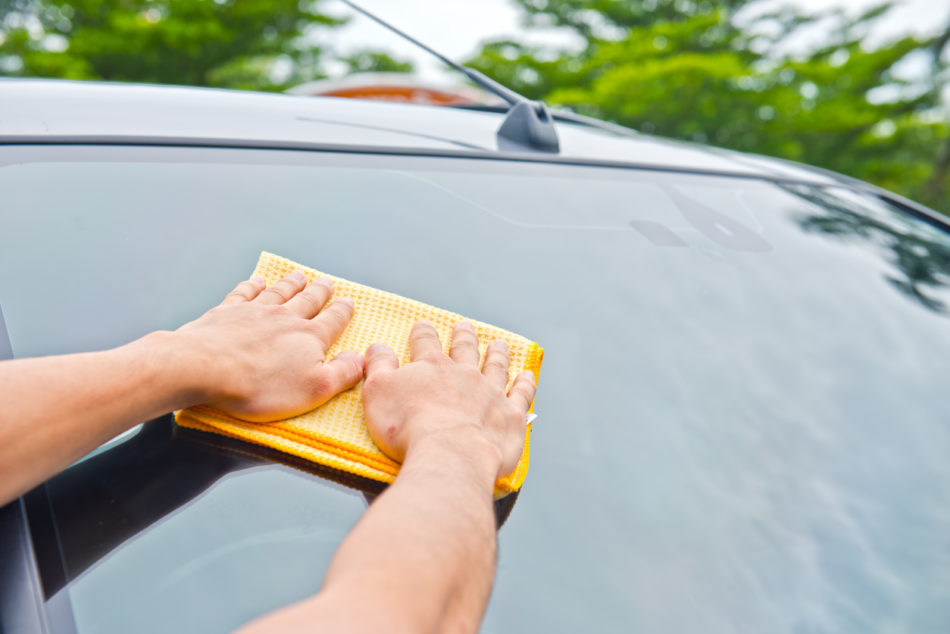 Cleaning car windshield with microfiber cloth