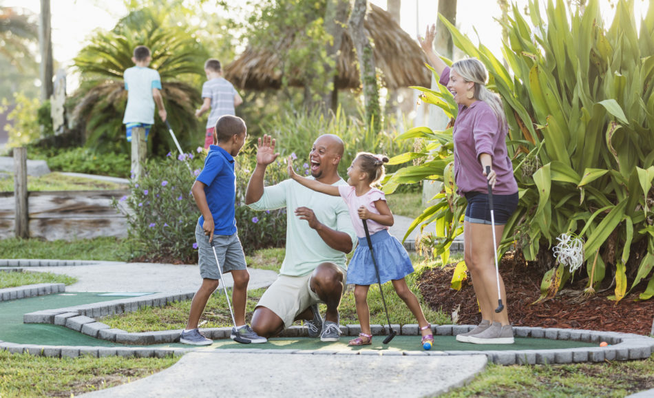 family having fun together and playing mini golf