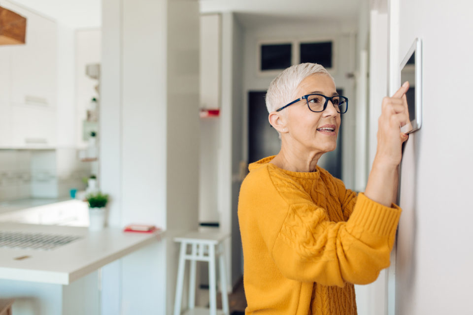 Portrait of a senior woman adjusting a smart system in her home