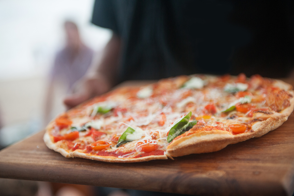 Waiter serving pizza