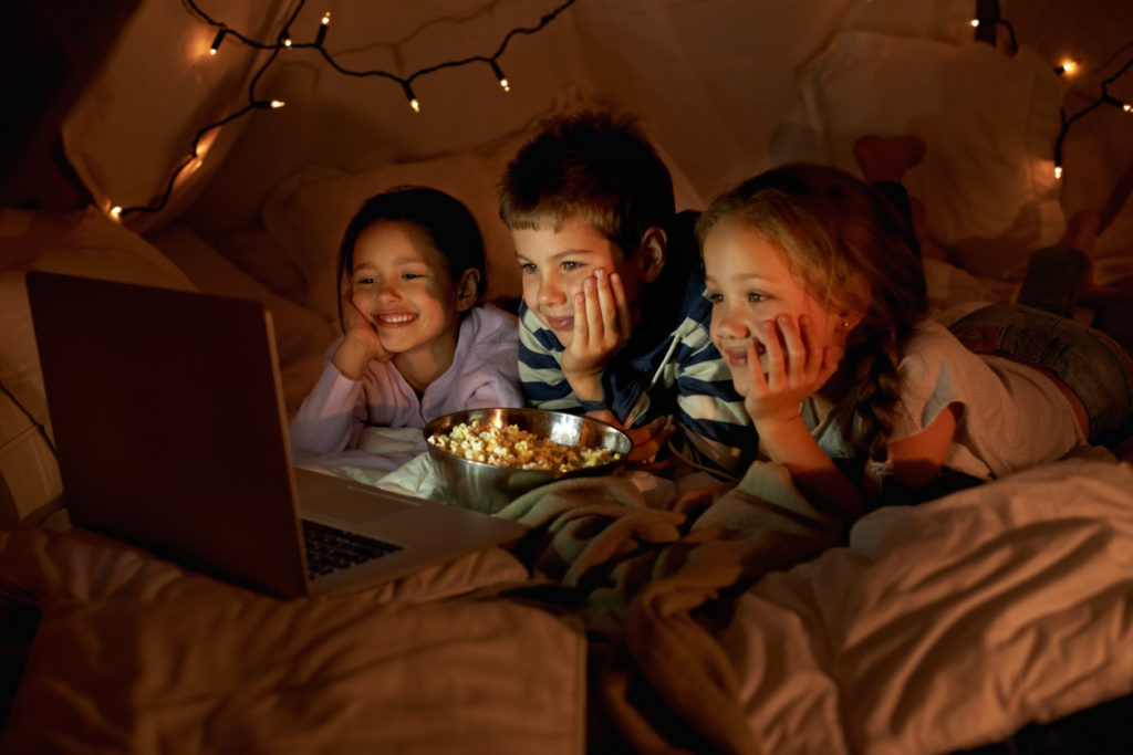 Shot of three young children using a laptop in a blanket
