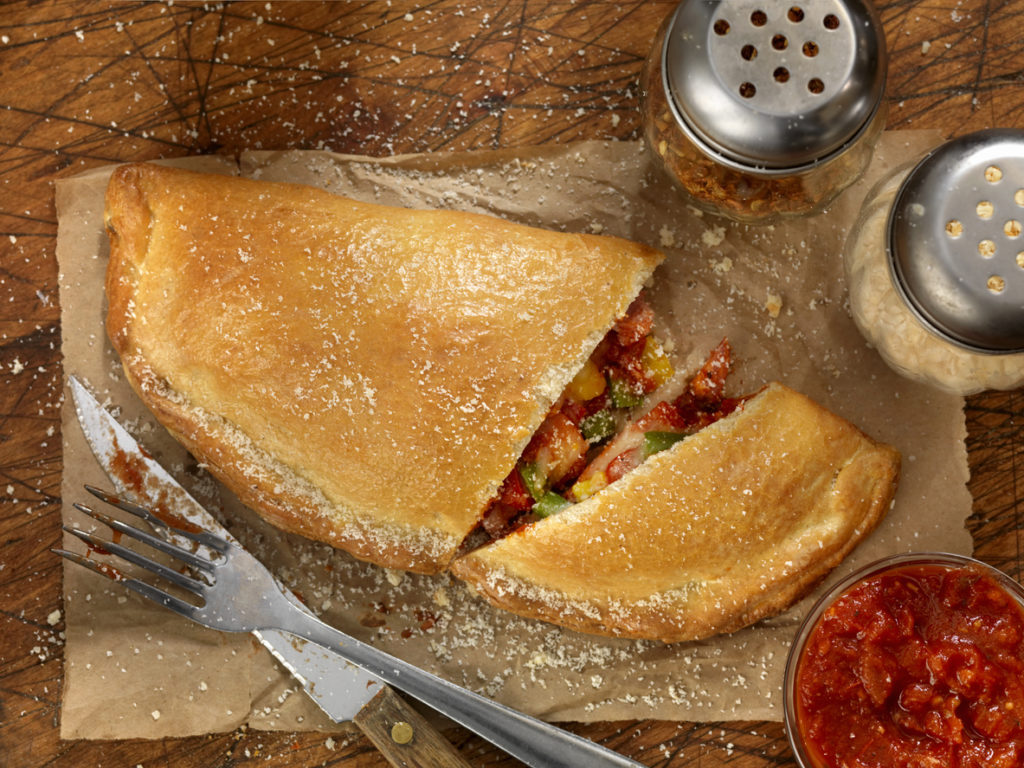 Authentic Hand Made Italian Calzone with Pepperoni, Sausage, Peppers, Fresh Parmesan and Marinara Sauce