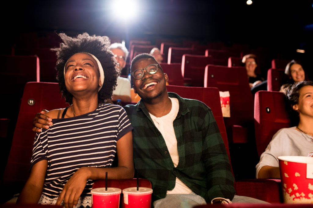 couple watching a comedy movie at the cinema and enjoying.